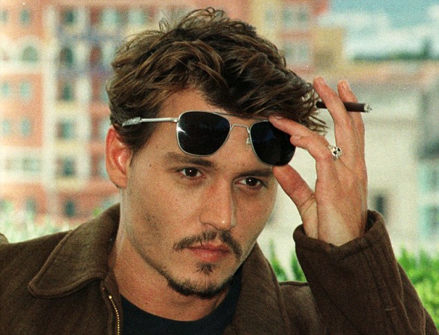 US movie star Johnny Depp removes  his sunglasses as  he poses for the press at the Festival Palace in Cannes on Friday May 15, 1998. Johnny Depp  stars in US director Terry Gilliam movie "Fear and loathing in Las Vegas" which will be screened today to the jury of the International Cannes Film festival.(AP PHOTO/Laurent Rebours)